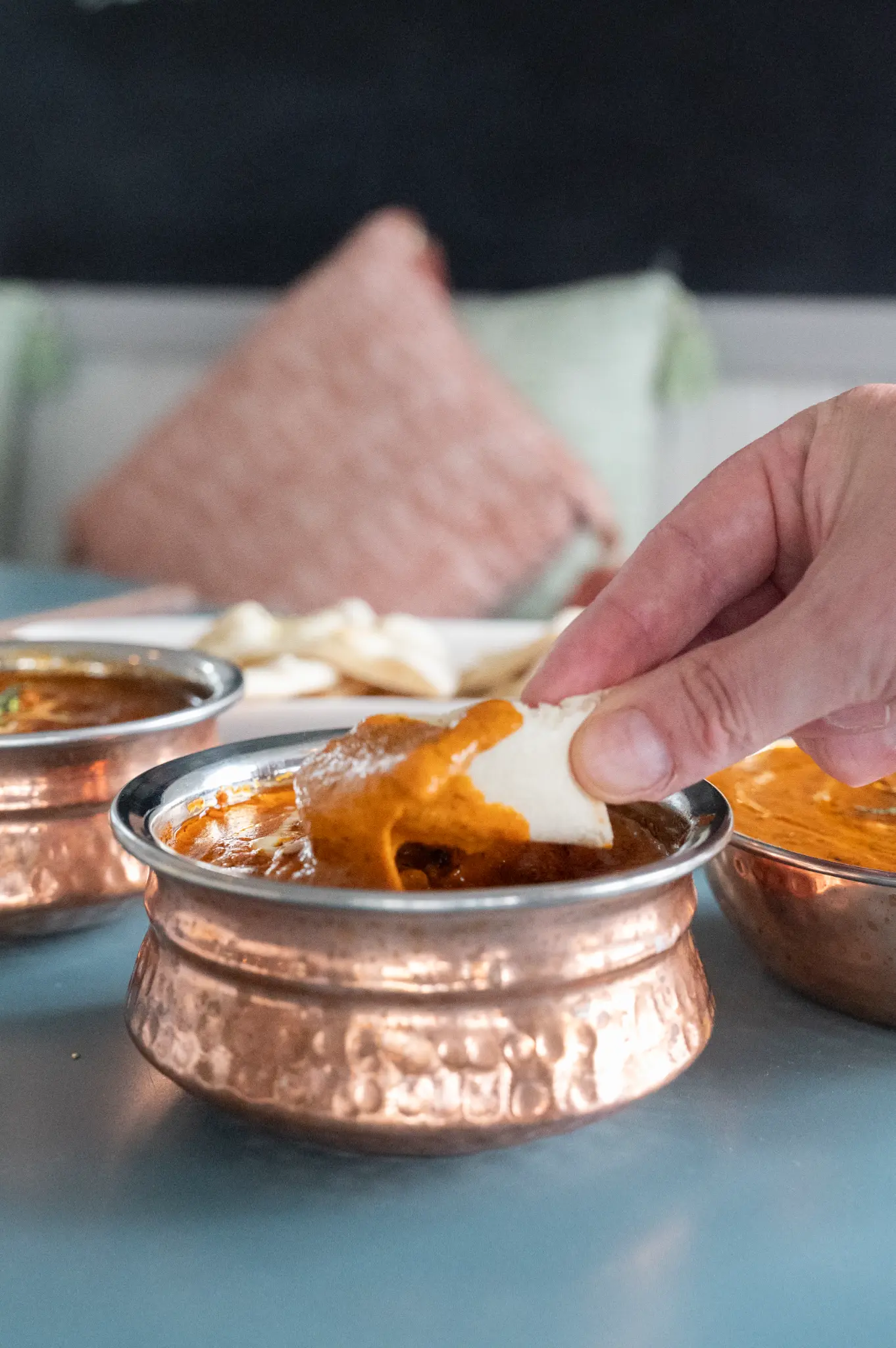 Naan pulled through curry sauce — Bombay at Bucklands